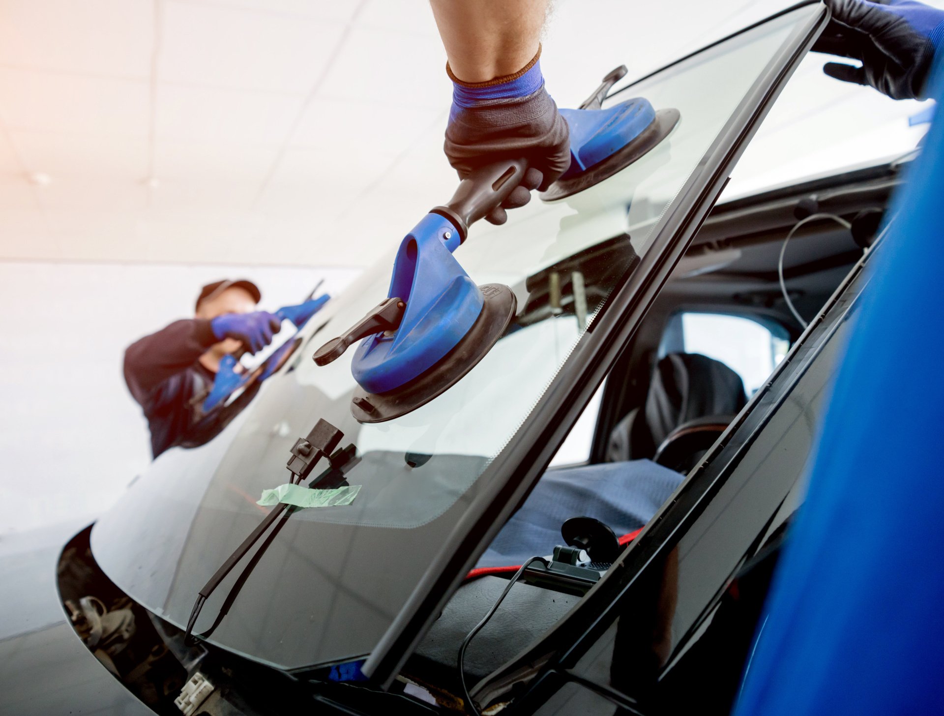 Mobile auto glass technician installing replacement windshield glass